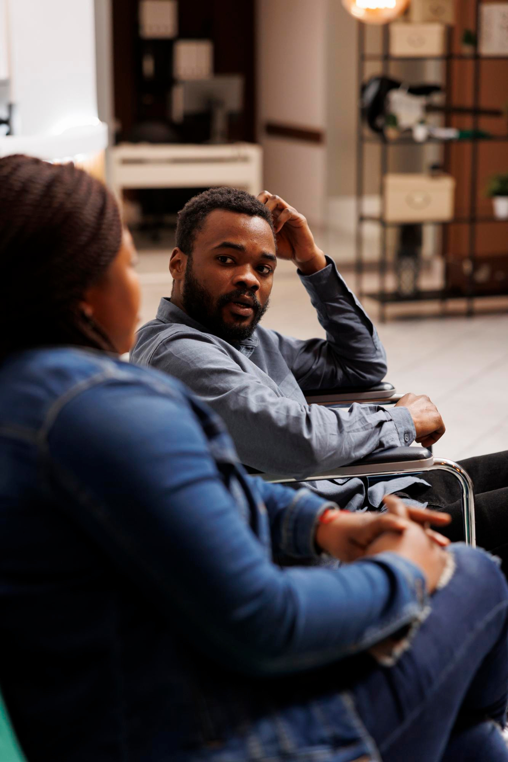 Man with hand on head looking distressed during a therapy session, representing men seeking mental health support