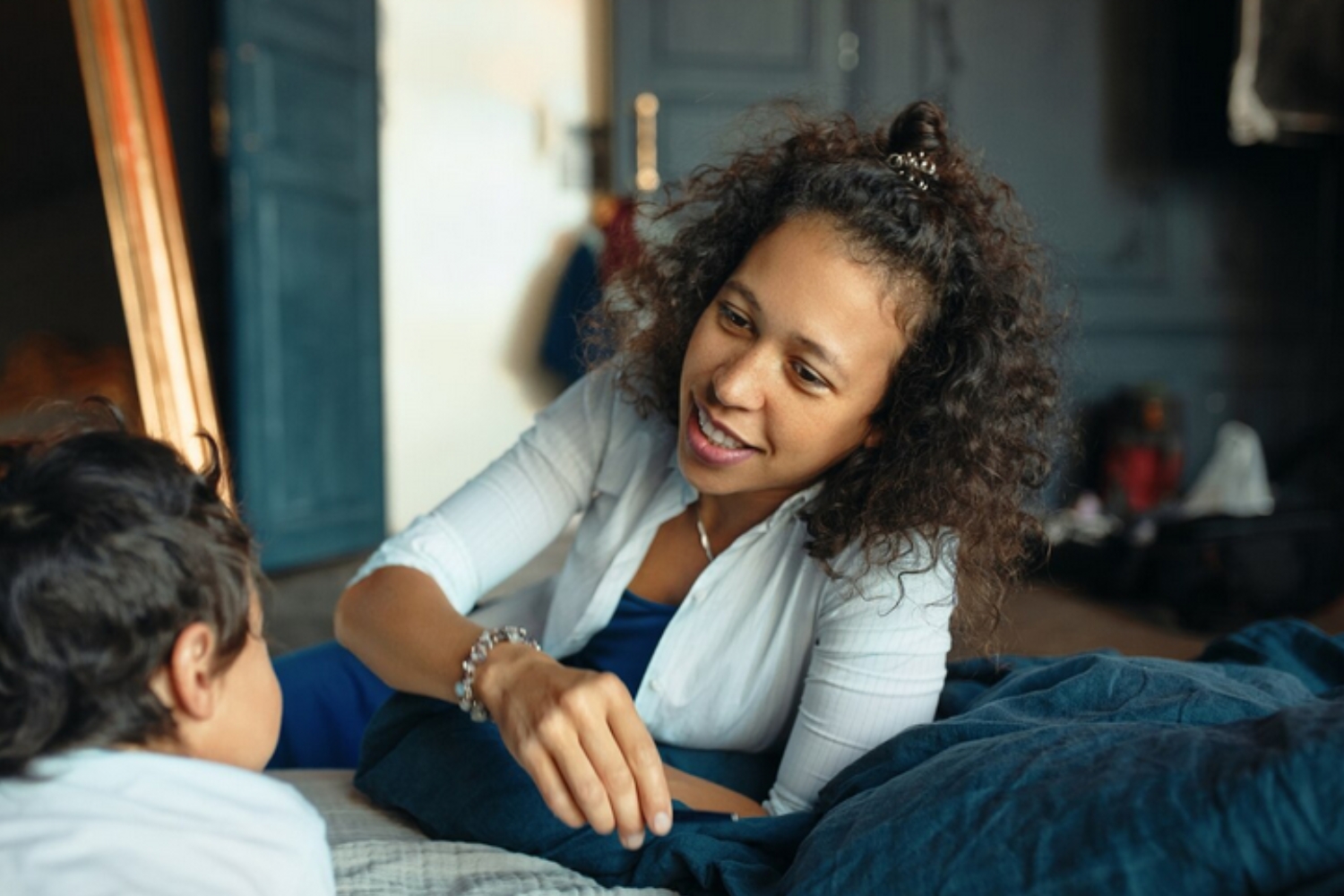Woman smiling warmly while talking with a child, representing emotional healing and supportive therapy