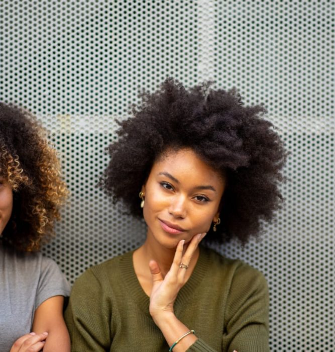Two confident women standing together, representing improved self-esteem and confidence through mental health support