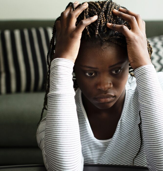 Woman gripping her hair with an intense expression, representing intrusive thoughts and distress associated with OCD